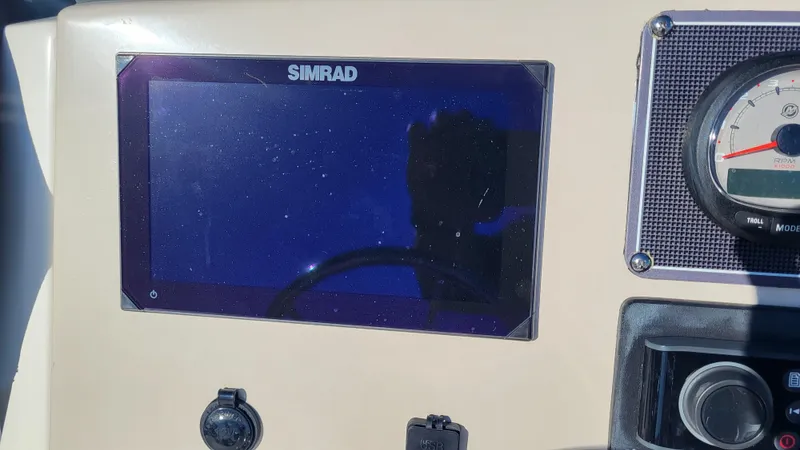 Slide: The Image of 2024 Boston Whaler 210 Montauk dashboard with Simrad display and gauges. - 9