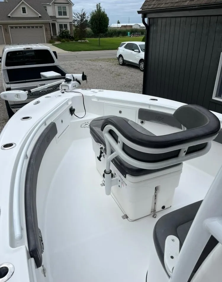 Slide: The Image of 2020 Crevalle 26 HBW boat with seating, parked near a house and vehicles. - 12