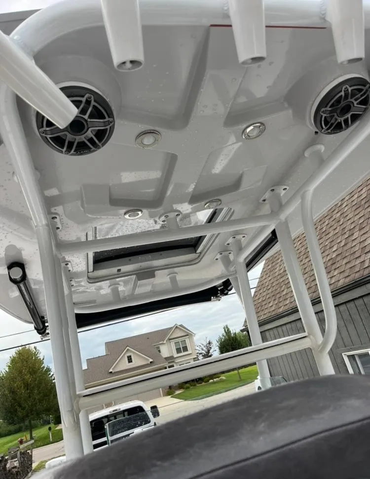 Slide: The Image of 2020 Crevalle 26 HBW boat T-top with speakers and rod holders, outdoor setting. - 19