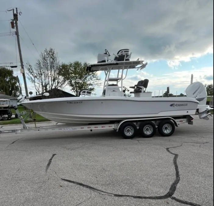 Slide: The Image of 2020 Crevalle 26 HBW boat on a trailer, parked on a street under cloudy skies. - 3