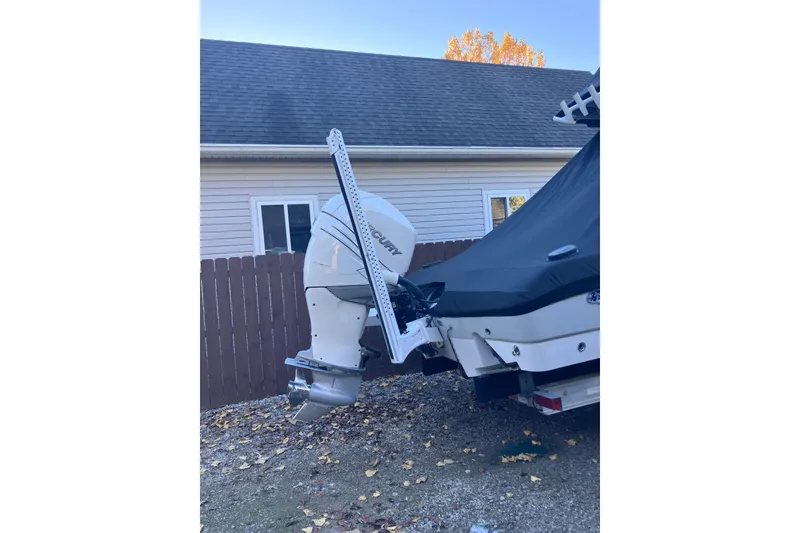 Slide: The Image of 2020 Crevalle 26 HBW boat with covered engine, parked near a house. - 36