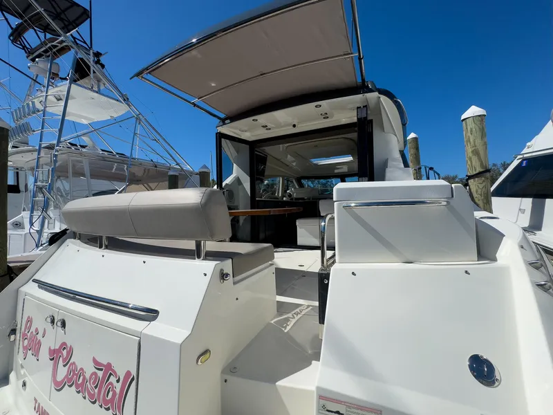 Slide: The Image of Rear view of a 2019 Carver C43 Coupe yacht docked at a marina. - 12