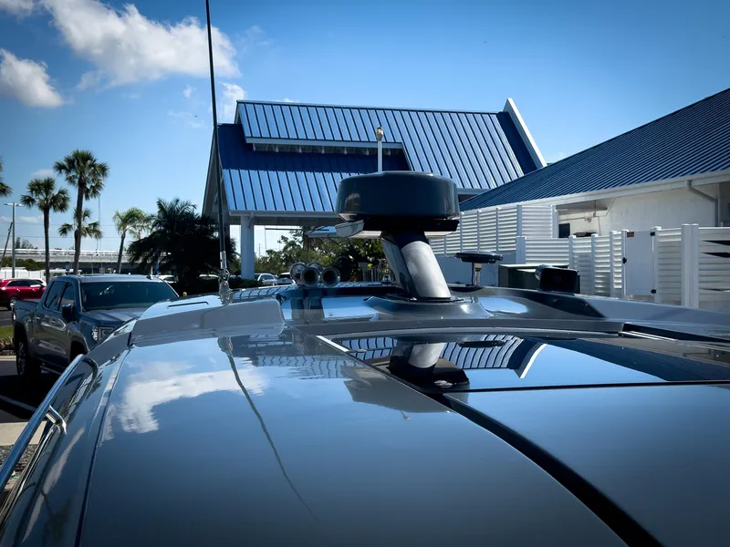 Slide: The Image of 2019 Carver C43 Coupe with rooftop equipment, parked near modern buildings and palm trees. - 30