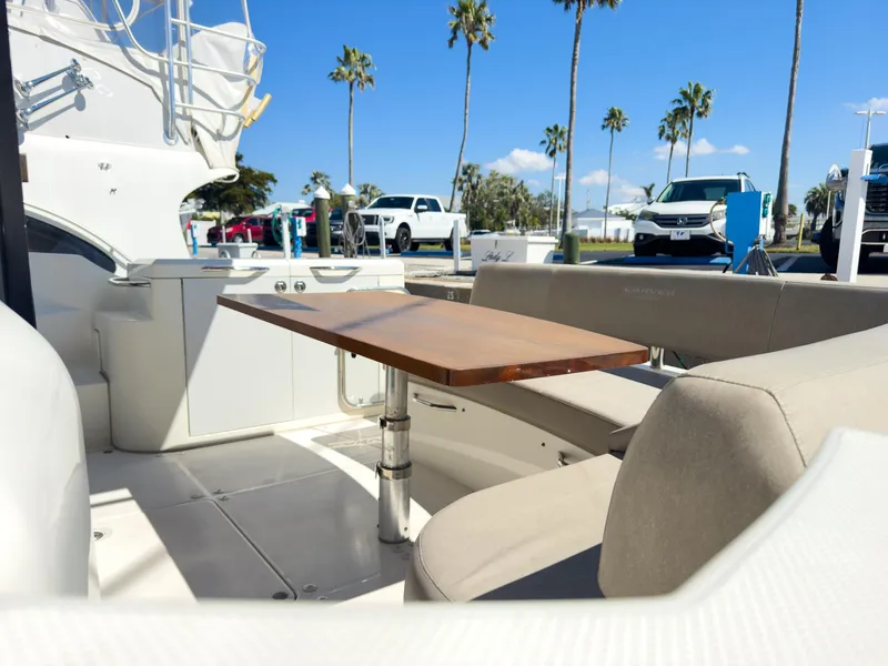 Slide: The Image of Luxury yacht deck with seating and table, parked cars, palm trees, and clear blue sky. - 10