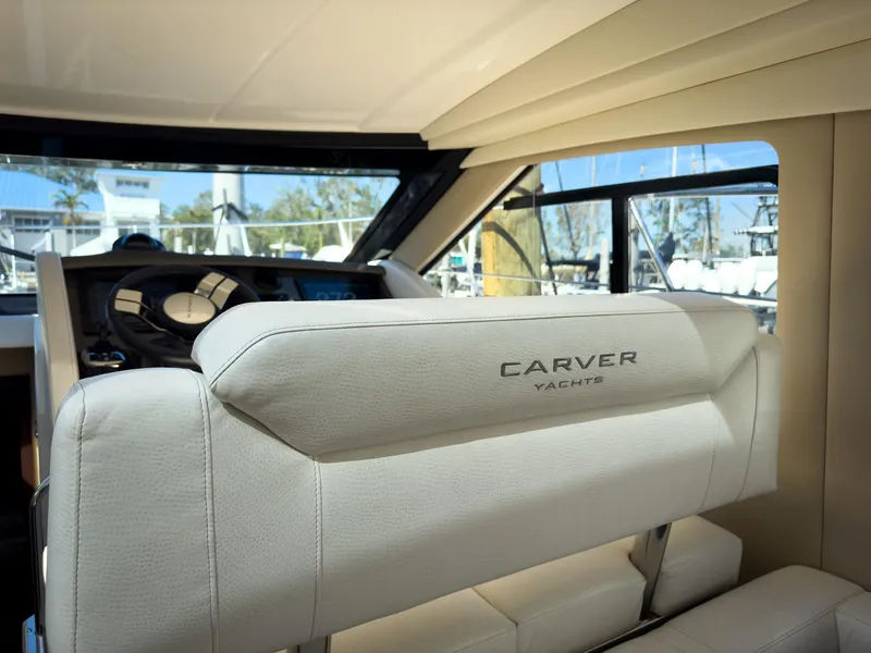 Slide: The Image of Interior of a 2019 Carver C43 Coupe yacht, featuring luxurious seating and helm. - 15
