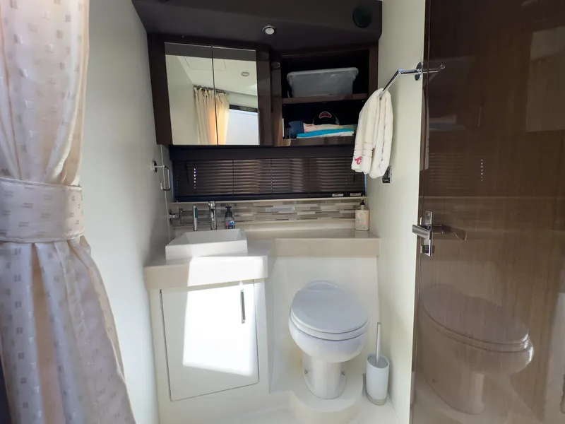 Slide: The Image of Modern bathroom interior in a 2019 Carver C43 Coupe yacht, featuring a sink and toilet. - 23