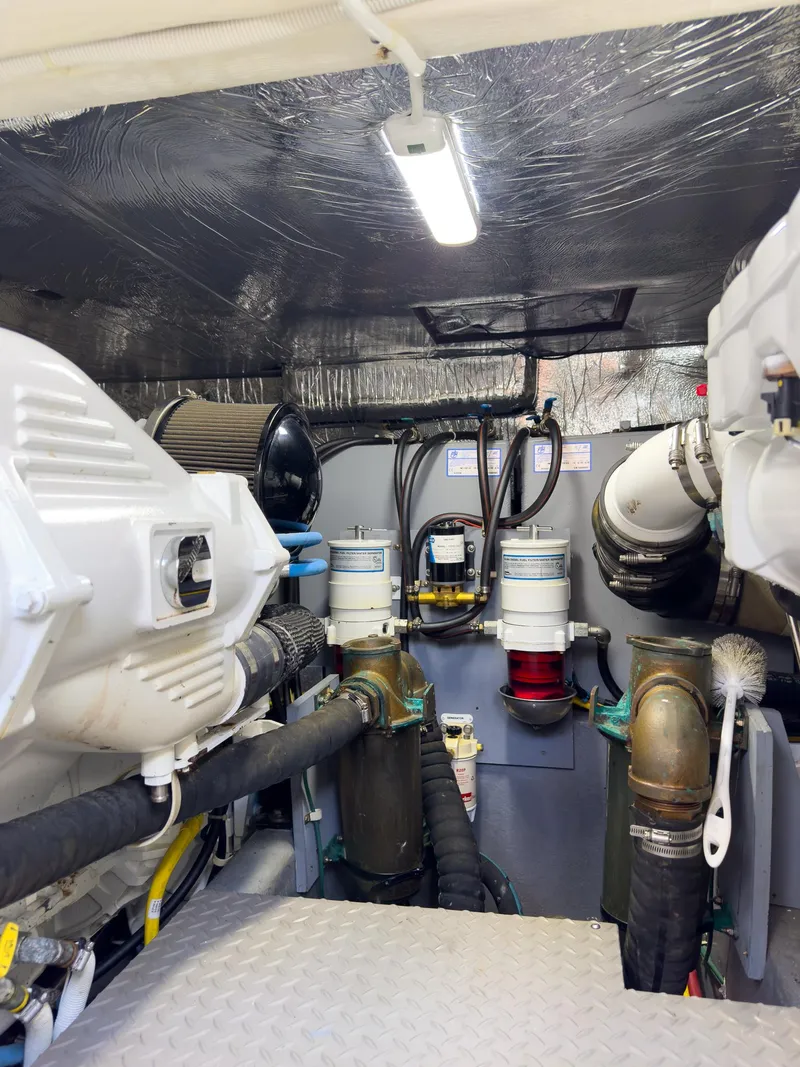 Slide: The Image of Engine room of a 2019 Carver C43 Coupe, showcasing mechanical components and piping. - 28