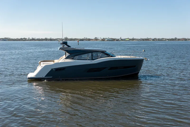 Slide: The Image of A sleek 2019 Carver C43 Coupe yacht cruising on calm waters under a clear sky. - 3