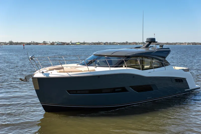 Slide: The Image of Luxurious 2019 Carver C43 Coupe yacht cruising on a serene lake under a clear blue sky. - 5