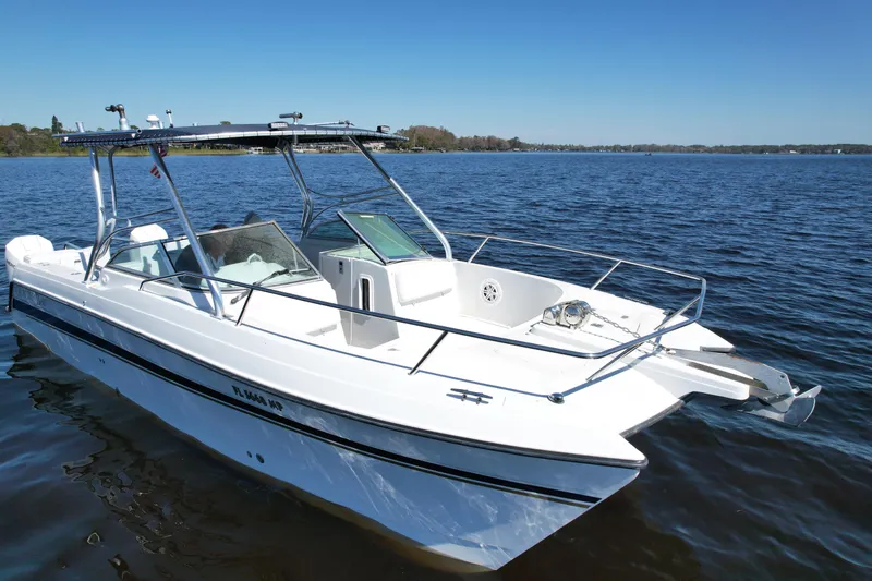 Slide: The Image of 2004 Glacier Bay Renegade 2640 boat on calm water under clear blue sky. - 13