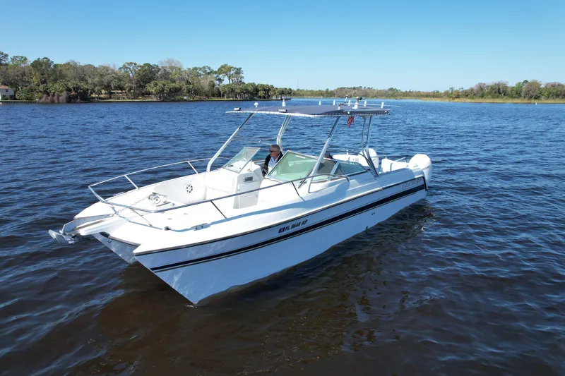 Slide: The Image of 2004 Glacier Bay Renegade 2640 boat on calm water under clear blue sky. - 16