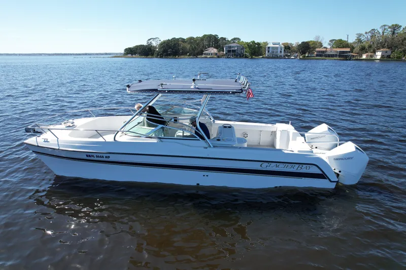 Slide: The Image of 2004 Glacier Bay Renegade 2640 boat on calm water, with scenic shoreline background. - 2