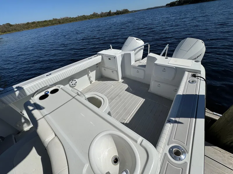 Slide: The Image of 2004 Glacier Bay Renegade 2640 boat on calm water, featuring spacious deck and seating. - 27