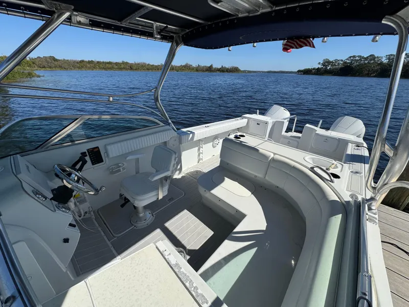 Slide: The Image of 2004 Glacier Bay Renegade 2640 boat interior with seating, steering wheel, and scenic water view. - 28