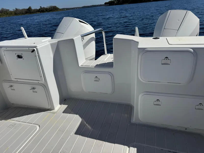 Slide: The Image of 2004 Glacier Bay Renegade 2640 boat deck with storage compartments and twin engines. - 31