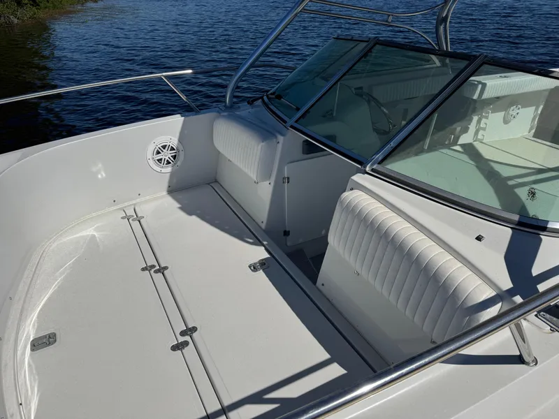 Slide: The Image of 2004 Glacier Bay Renegade 2640 boat interior with seating and windshield, on calm water. - 33