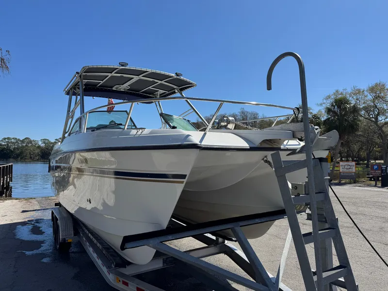 Slide: The Image of 2004 Glacier Bay Renegade 2640 catamaran on trailer by a lake under clear sky. - 46