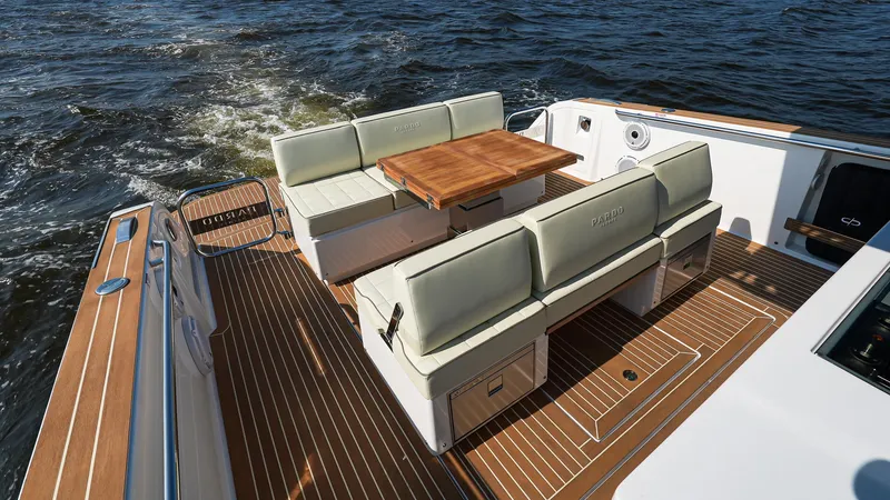 Slide: The Image of 2025 Pardo Yachts 38 Walkaround, elegant deck seating with wooden table on open water. - 10
