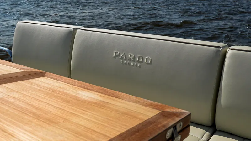 Slide: The Image of 2025 Pardo Yachts 38 Walkaround, luxury seating and wooden table, ocean backdrop. - 15