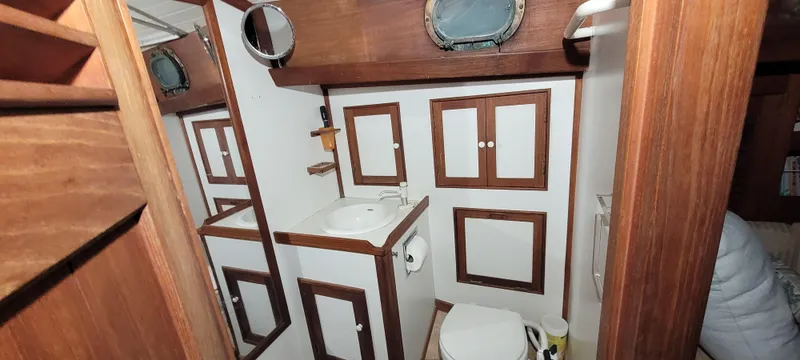 Slide: The Image of 1980 Shannon 38 Ketch bathroom with wooden cabinetry and porthole window. - 11