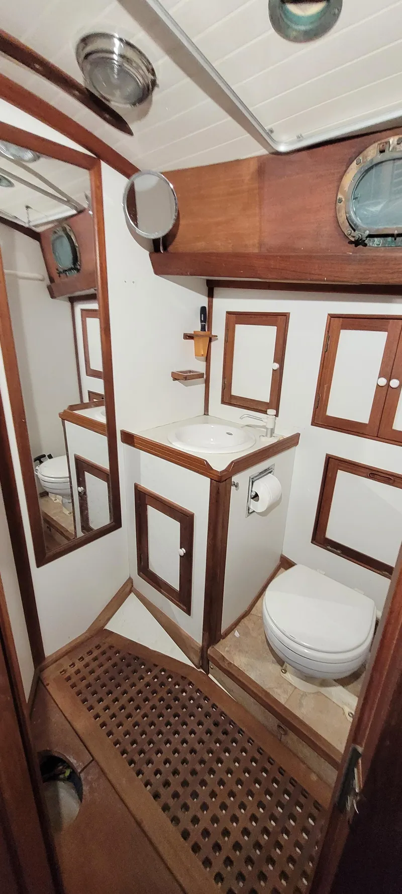 Slide: The Image of 1980 Shannon 38 Ketch bathroom with wooden cabinetry and nautical decor. - 18