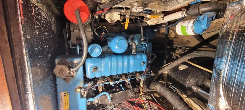 Slide: The Image of Engine compartment of a 1980 Shannon 38 Ketch sailboat, featuring a blue marine engine. - 29