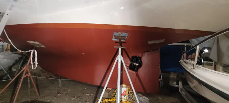 Slide: The Image of 1980 Shannon 38 Ketch sailboat hull in dry dock, supported by stands. - 45