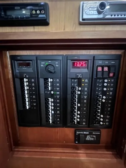 Slide: The Image of Electrical control panel in a 2011 Sabre 40 Sedan boat, featuring various switches and displays. - 23