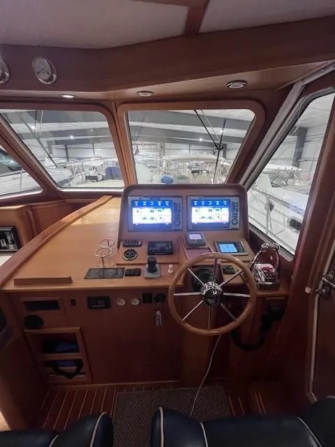 Slide: The Image of 2011 Sabre 40 Sedan helm with dual navigation screens and wooden steering wheel. - 25