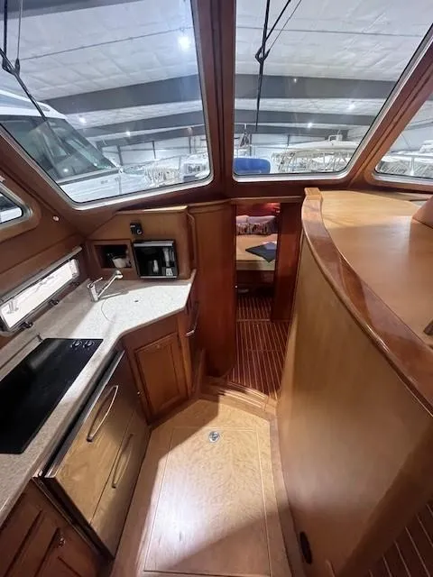 Slide: The Image of 2011 Sabre 40 Sedan interior with wood finish and modern kitchen amenities. - 32