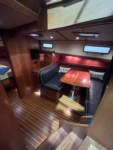 Slide: The Image of 2011 Sabre 40 Sedan interior with wood flooring, dining area, and cozy seating. - 35