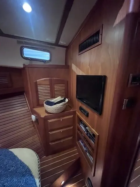 Slide: The Image of 2011 Sabre 40 Sedan interior with wood paneling, TV, and storage drawers. - 40
