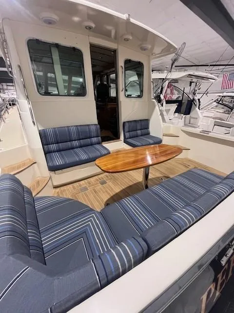 Slide: The Image of 2011 Sabre 40 Sedan yacht with striped seating and wooden table on deck. - 7