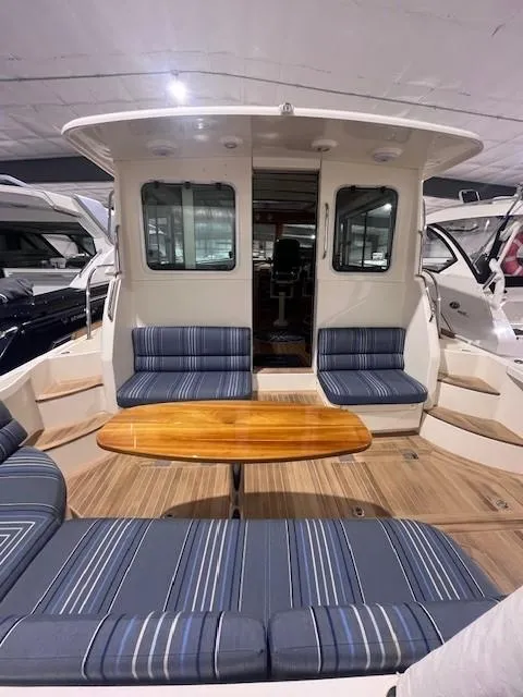 Slide: The Image of 2011 Sabre 40 Sedan yacht interior with striped seating and wooden table. - 8