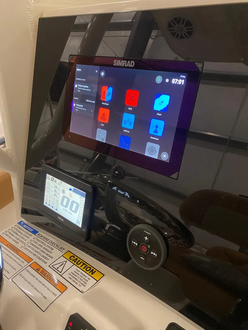 Slide: The Image of 2023 NauticStar 242L Offshore dashboard with Simrad display and controls. - 10