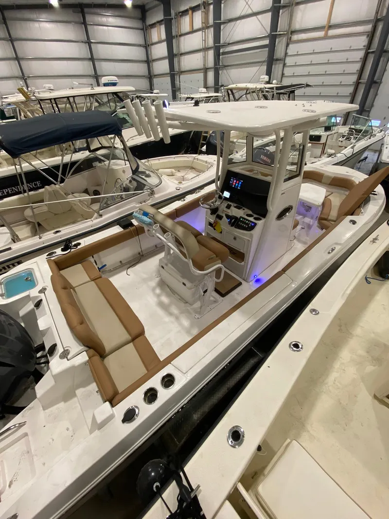 Slide: The Image of 2023 NauticStar 242L Offshore boat in indoor storage, featuring spacious seating and modern controls. - 11