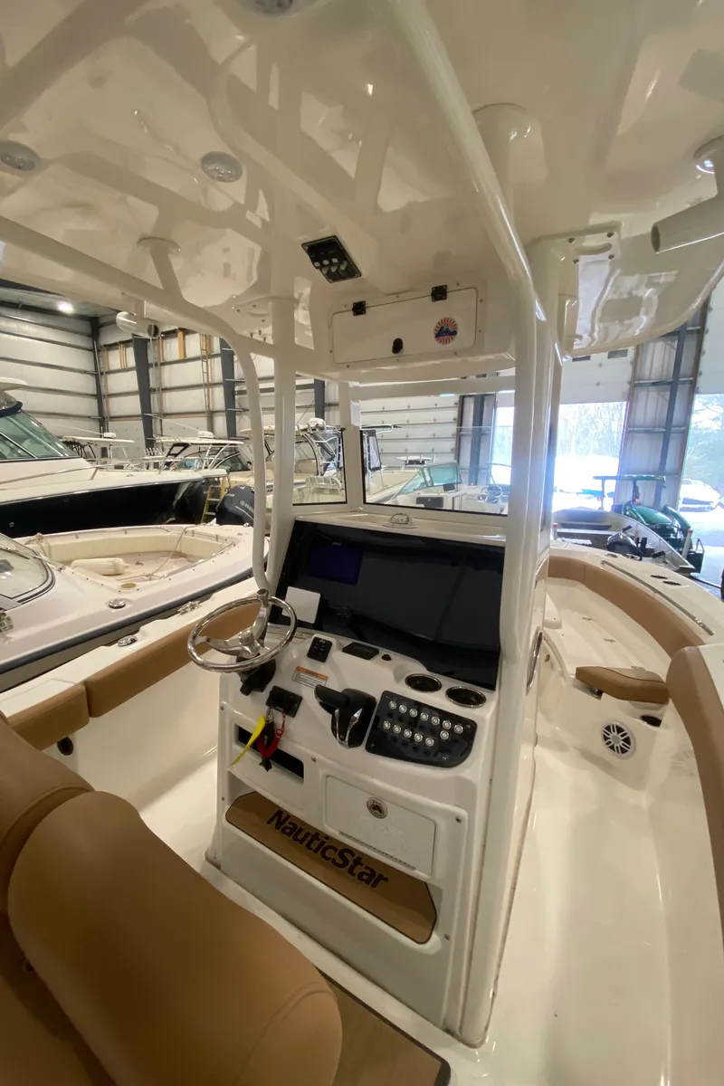 Slide: The Image of 2023 NauticStar 242L Offshore boat interior with modern dashboard and controls. - 8