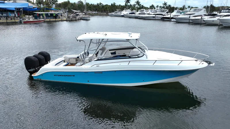 Slide: The Image of 2008 Hydra-Sports Vector 3300 VX boat docked in marina, featuring sleek design and triple engines. - 0