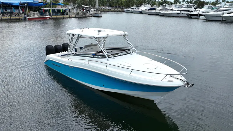 Slide: The Image of 2008 Hydra-Sports Vector 3300 VX boat docked in a marina, featuring a sleek white and blue design. - 2