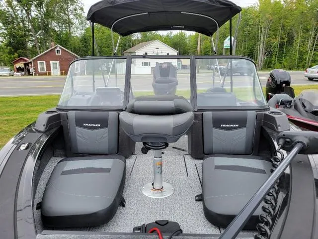 Slide: The Image of 2024 Tracker Targa™ V-19 Combo boat interior with seating and windshield, parked outdoors. - 5