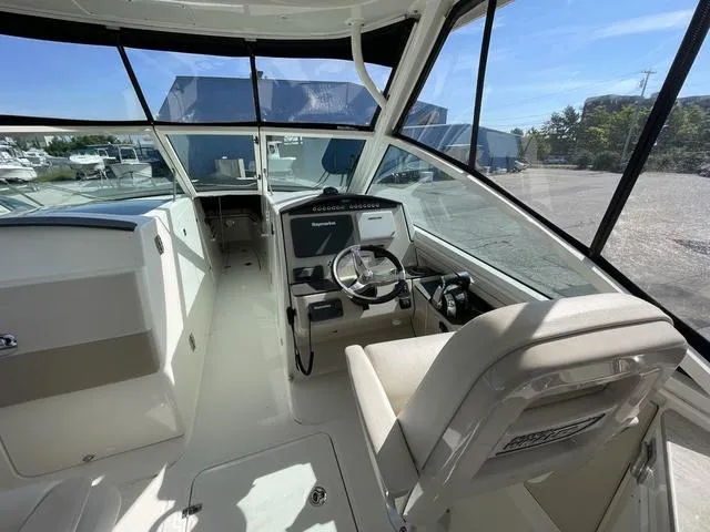 Slide: The Image of 2016 Boston Whaler 320 Vantage cockpit with steering wheel and navigation equipment. - 13