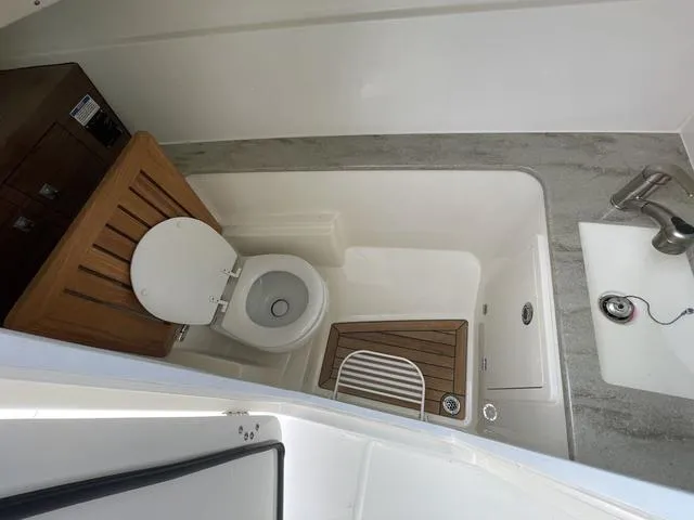 Slide: The Image of 2016 Boston Whaler 320 Vantage boat bathroom interior with toilet and sink. - 20