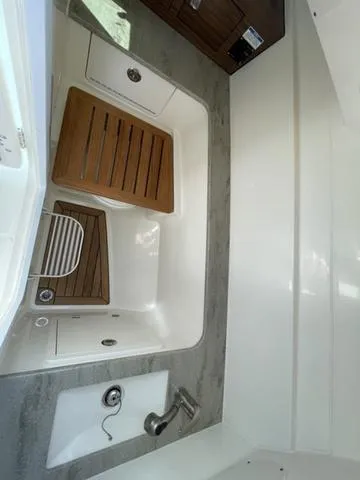Slide: The Image of 2016 Boston Whaler 320 Vantage interior with wood accents and modern fixtures. - 24