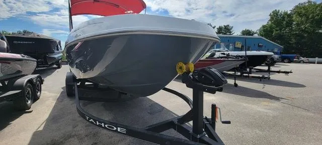 Slide: The Image of 2024 Tahoe T21 boat on trailer, parked outdoors under a partly cloudy sky. - 11