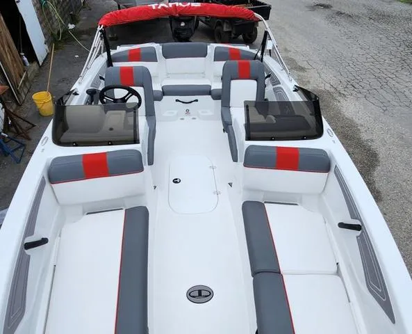 Slide: The Image of 2024 Tahoe T21 boat interior with red and gray seating, steering wheel, and windshield. - 4