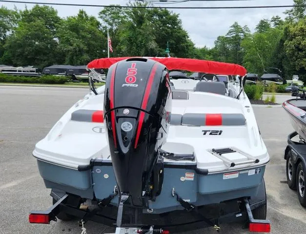Slide: The Image of 2024 Tahoe T21 boat with red canopy and powerful outboard motor, parked outdoors. - 7