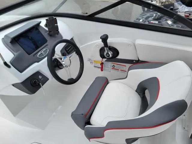 Slide: The Image of 2024 Tahoe 210 S boat cockpit with steering wheel, control panel, and cushioned seat. - 11