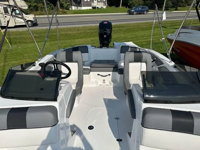 Slide: The Image of 2024 Tahoe T21 boat interior with seating, steering wheel, and windshield, displayed outdoors. - 10