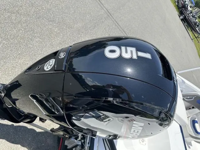 Slide: The Image of 2024 Tahoe 200 S boat with a Mercury 150 outboard motor, parked on pavement. - 4