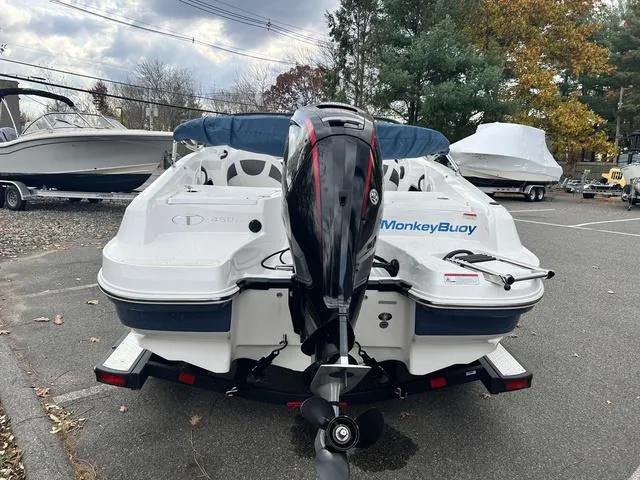 Slide: The Image of 2021 Tahoe 450 TS boat with outboard motor, parked outdoors on a trailer. - 5